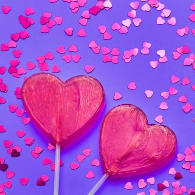 valentines-day-background-two-candy-hearts-with-glitter-purple-backdrop-top-view-copy-space
